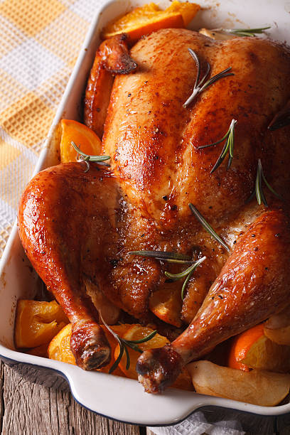 istock baked chicken with oranges in the baking dish close-up. Vertical 599904866