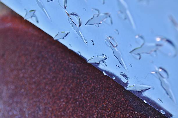 New metal sheet with raindrops over the old and rusty metal. 