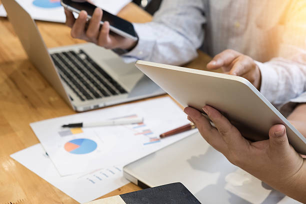 istock business man partners using touchpads and smartphone at meeting 599906748