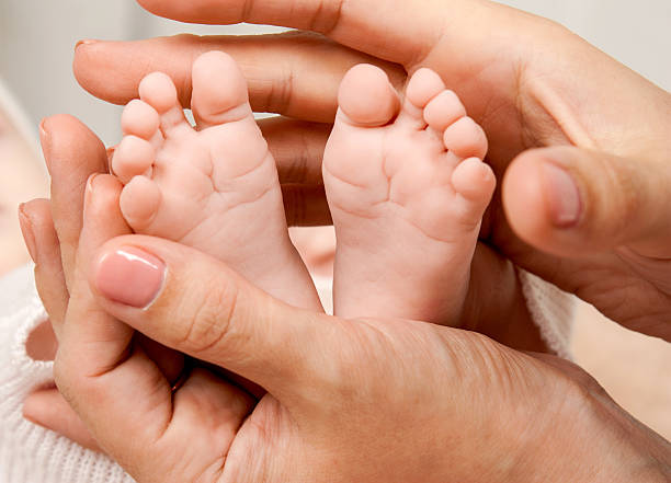 istock Baby feet in mom's hands 599909870