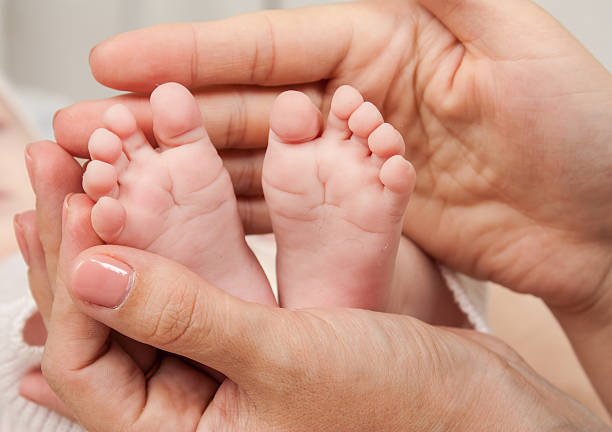 istock Mother holds baby's feet in the hands 599910070