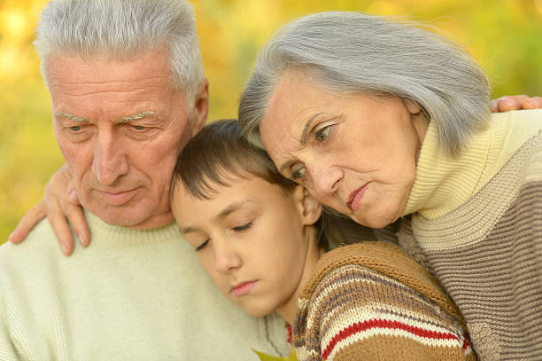 istock Sad grandparents with boy in park 599910436