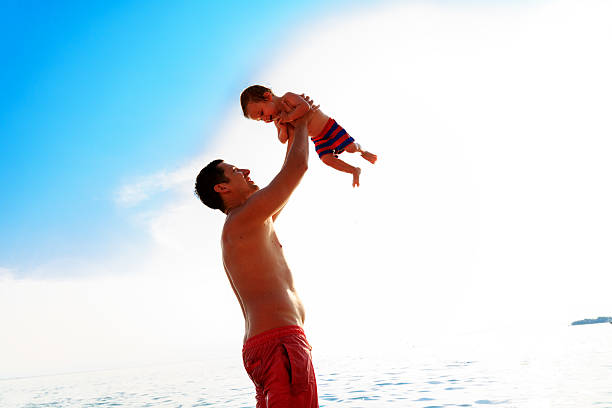 istock Father throws son in the air 599912846