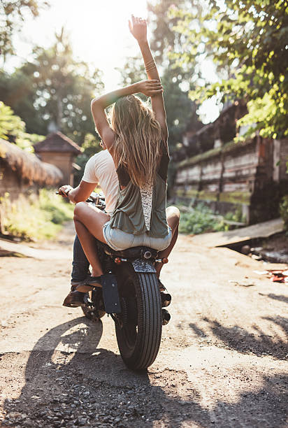istock Young couple riding motorcycle on rural road 599913346