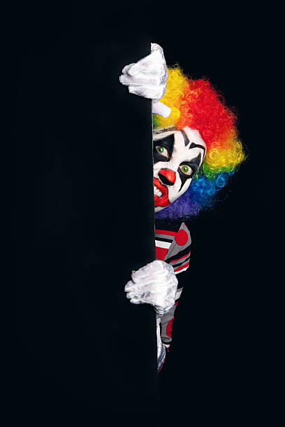 A creepy clown peeking around a dark corner.