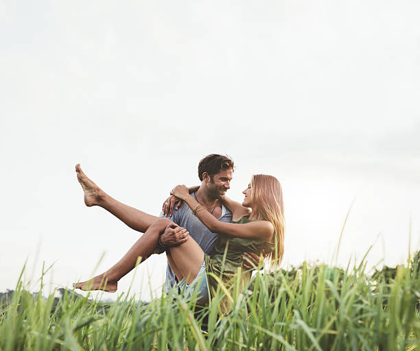 istock Romantic man carrying woman in field 599913606