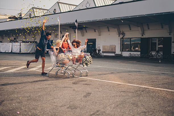 Friends racing with shopping carts on road