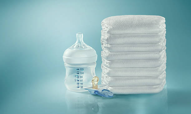istock Stack of diapers. Baby bottle and pacifier. Studio Shot. Isolated 599951398