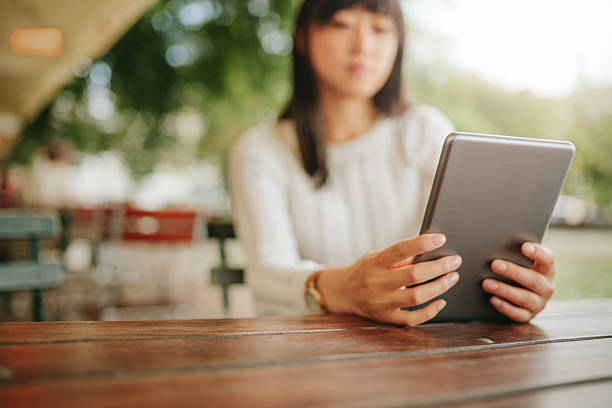 istock Female using digital tablet at outdoor cafe 599951988