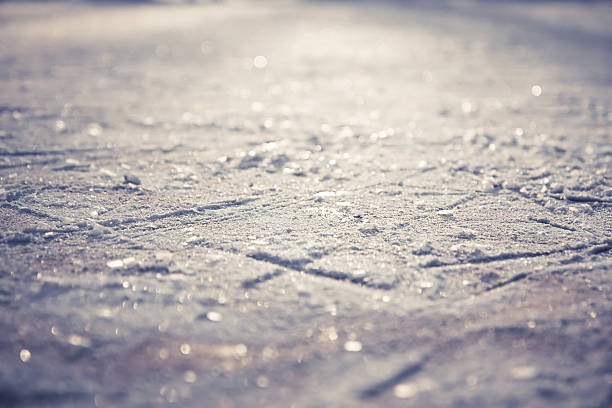 Winter pattern from snowflakes on shining ice skating rink Winter pattern from figure skates on shining ice skating rink with snowflakes as Christmas background icicle snowflake winter brilliant stock pictures, royalty-free photos & images