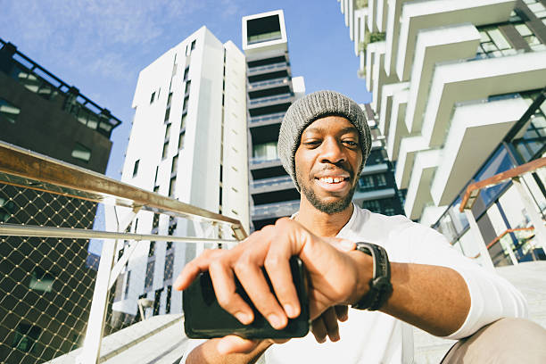 istock Cheerful Young Man Using His Smartwatch And Smartphone 599957034