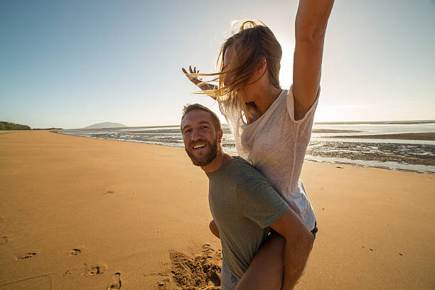 istock Playful young couple on the beach at sunset 599957170