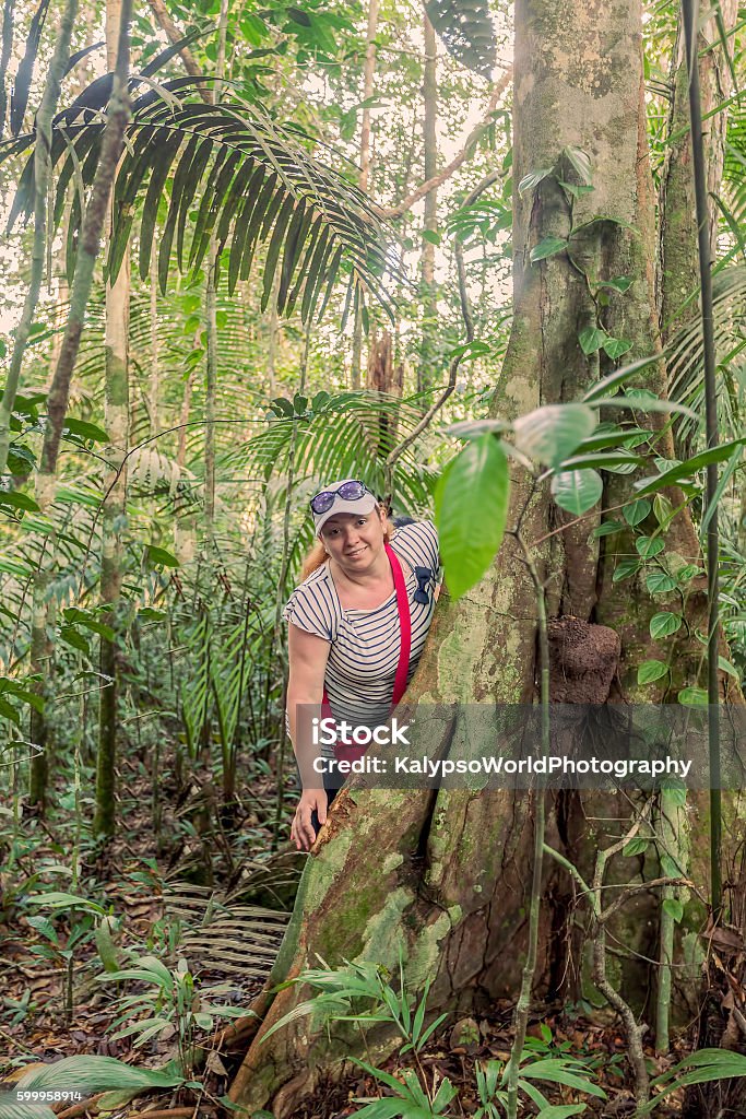 Happy Woman Standing Next To A Kapok Tree Young Caucasian Happy Woman Standing Next To A Kapok Tree, Ceiba Pentandra In Cuyabeno National Park, South America Adult Stock Photo