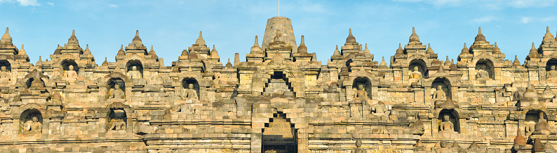 Panoramic view of Borobudur temple's top tiers facade with all its Buddha statues and niches.