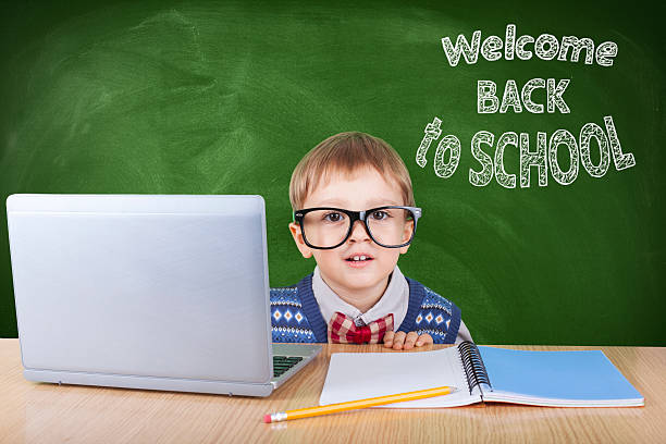 istock Child with laptop peeking in the classroom 599959216