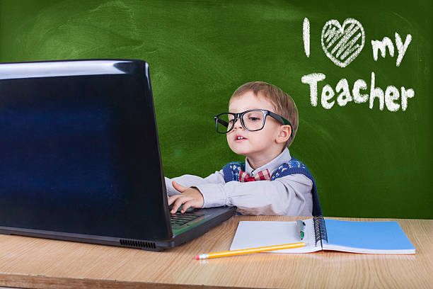istock Child with laptop peeking in the classroom 599959340