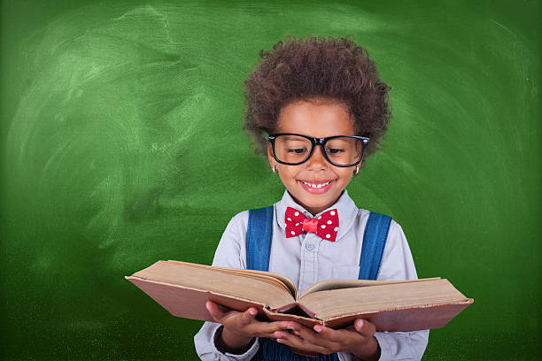 Schoolboy reading a book in front of school board