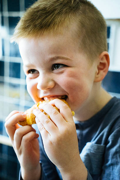 istock Happy Young Boy Having Breakfast, Eating Croissant 599959464