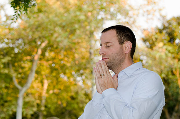 istock Man praying outdoors. 599959524