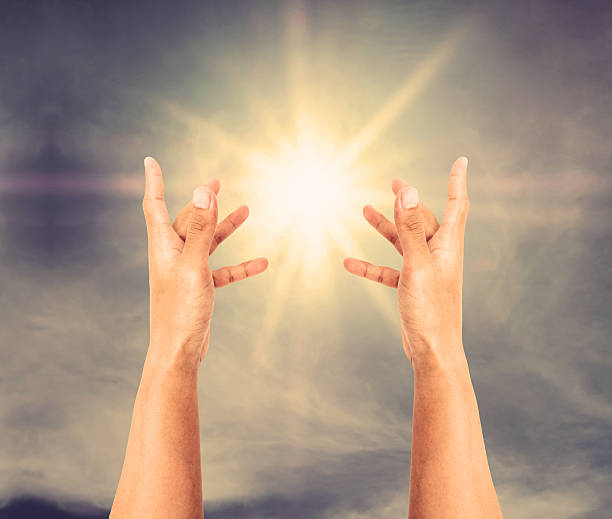 istock Hand trying to reach on the sky with sun rays 599966114