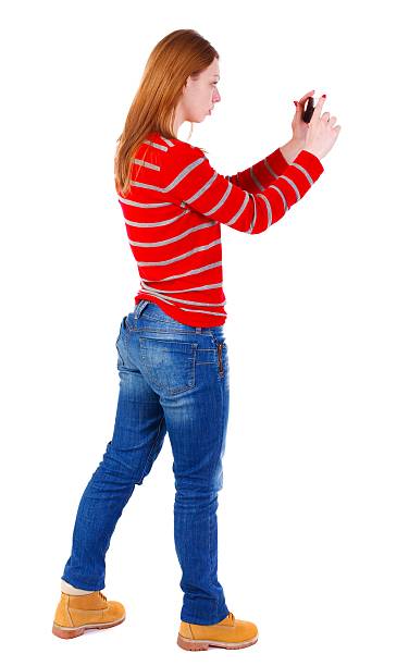 istock back view of standing young beautiful  woman  using a mobile 599968000