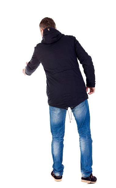 istock man in jacket holds out his hand for handshake. 599968060