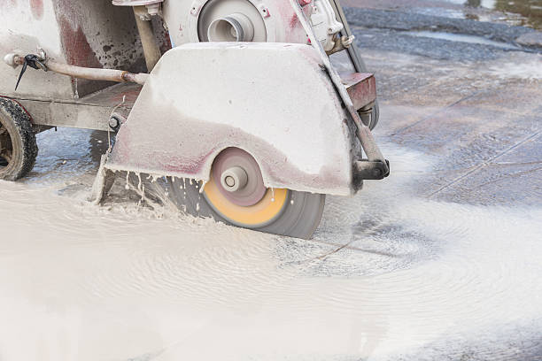 istock Worker cutting concrete road with diamond saw blade machine 599968308