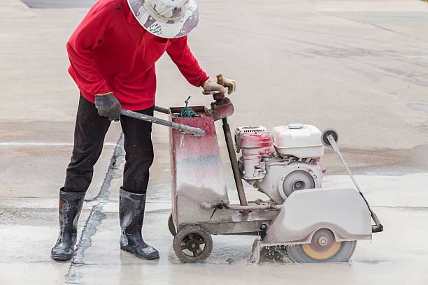 istock Worker cutting concrete road with diamond saw blade machine 599968782