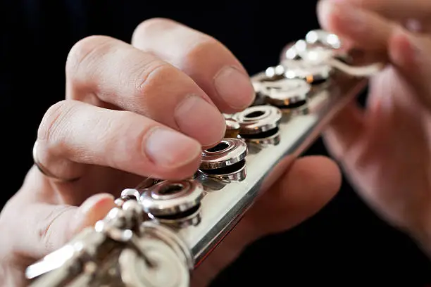 Photo of Detail of a musician flute in his hands closeup