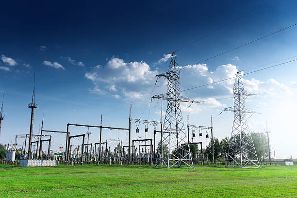 kraftwerk tagsüber am blauen himmel - stromnetz stock-fotos und bilder