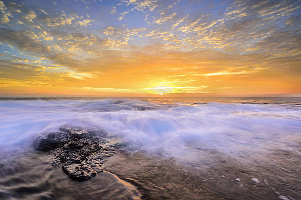 wave flows over weathered rocks and boulders at North Narrab
