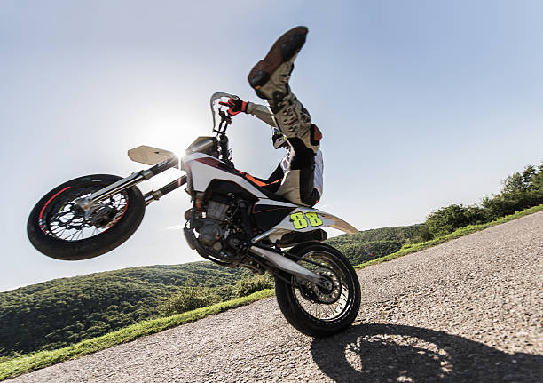 istock Side view of motorcyclist balancing on front wheel in nature. 599974782