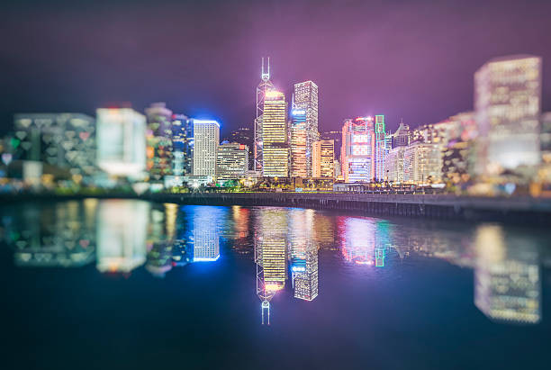 istock modern illuminated buildings along coastline,hong kong 599979056