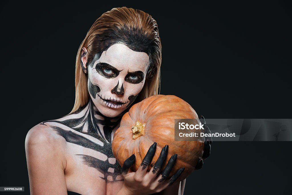 Mujer Con Maquillaje Esqueleto De Halloween Sosteniendo Calabaza Foto de  stock y más banco de imágenes de Adornos corporales - iStock