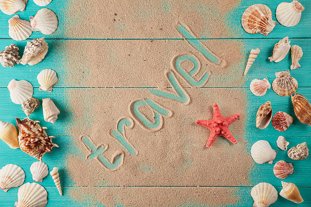istock Word travel written on sand among seashells 599986816