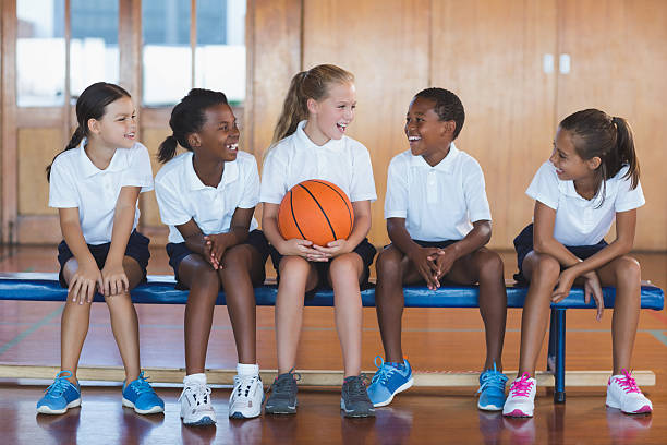 les écoliers s’amusent sur un terrain de basket-ball - éducation physique photos et images de collection