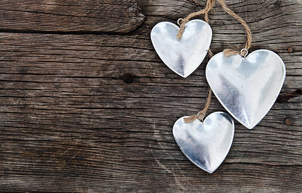 istock Metal hearts on wooden background 599988536