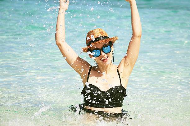istock Young playful girl splashing on the beach 599990126