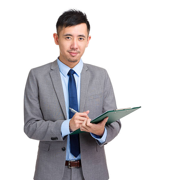 istock Chinese businessman writing on a clipboard 599993374