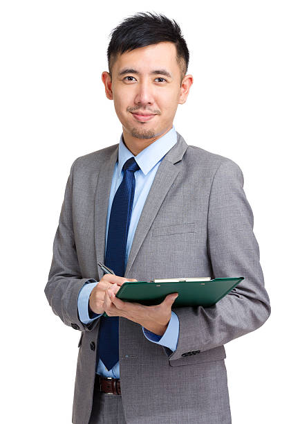 istock Chinese businessman writing on a clipboard 599993454