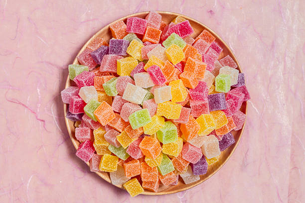 istock Colorful candy and jelly in dish on pink background 599993692