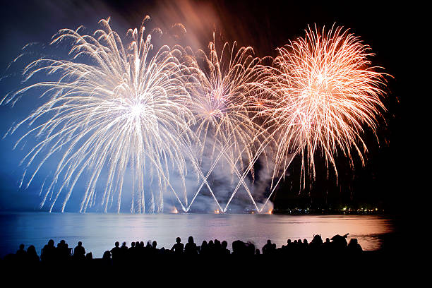 istock Long exposure large colorful fireworks with unrecognizable crowd people watching 599994428