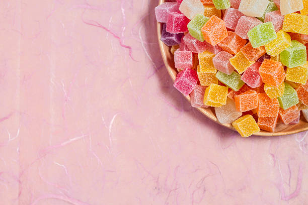 istock Colorful candy and jelly in dish on pink background 599995144