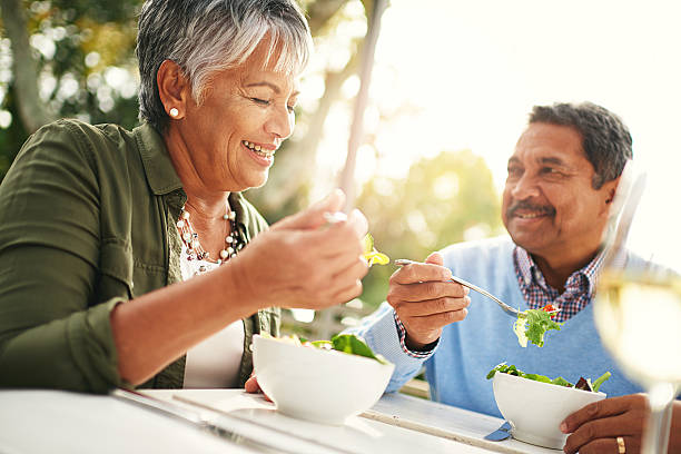 Healthiness and happiness go hand in hand Shot of a happy older couple enjoying a healthy lunch together outdoors eating stock pictures, royalty-free photos & images