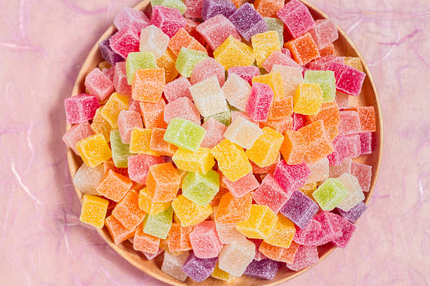 istock Colorful candy and jelly in dish on pink background 599995274