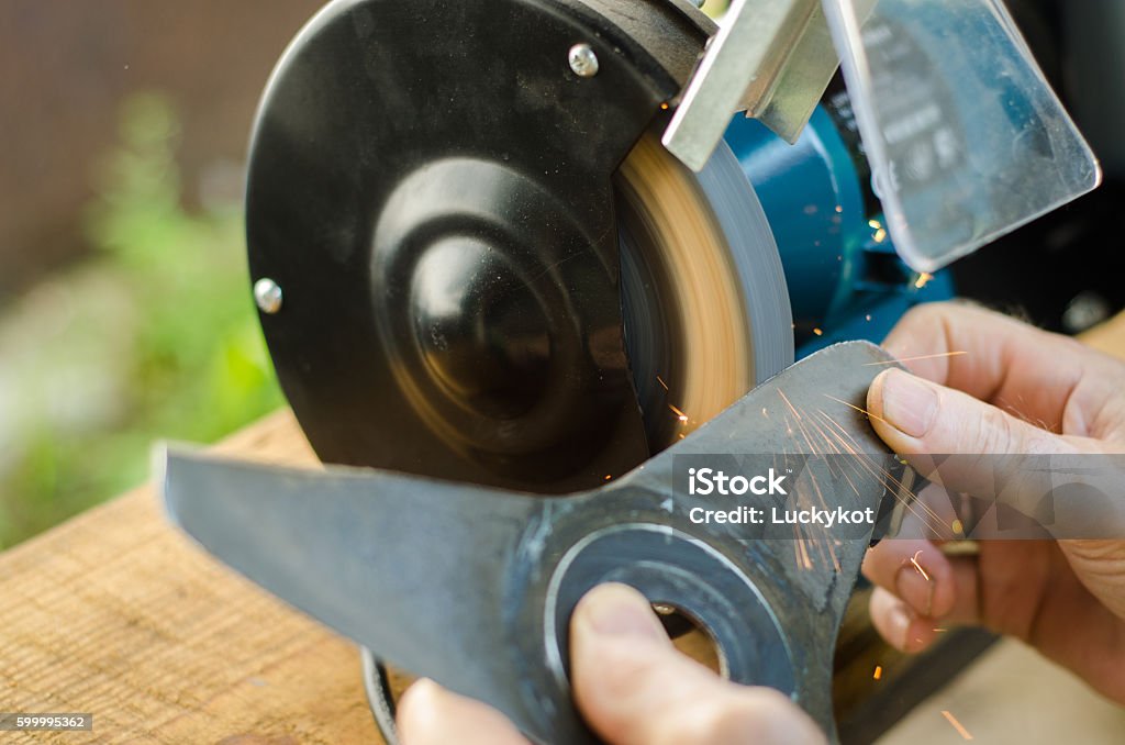 Arbeiter schärft seinen Klingenrasenmäher. - Lizenzfrei Rasenmäher Stock-Foto