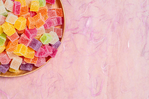 istock Colorful candy and jelly in dish on pink background 599995416