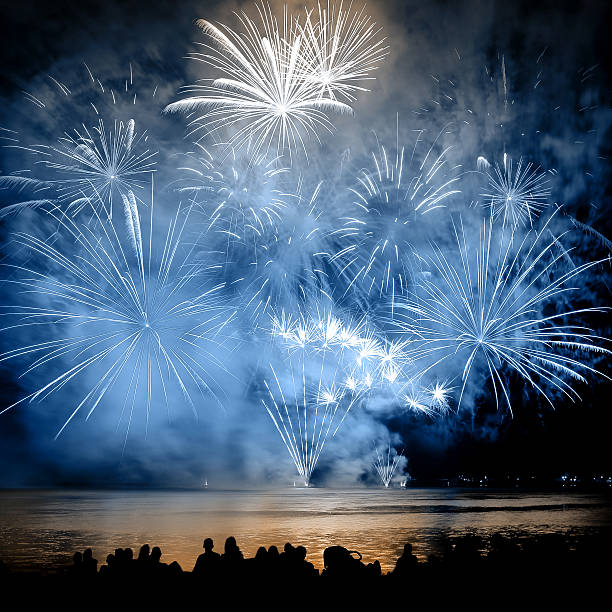 schönes großes buntes feuerwerk mit unkenntlich zu erkennenden menschenmengen - new years day fotos stock-fotos und bilder