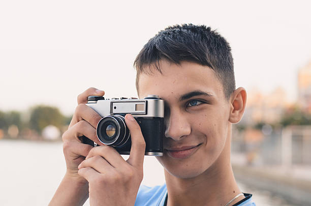 istock Cute boy teenager with vintage rangefinder camera. 599995910