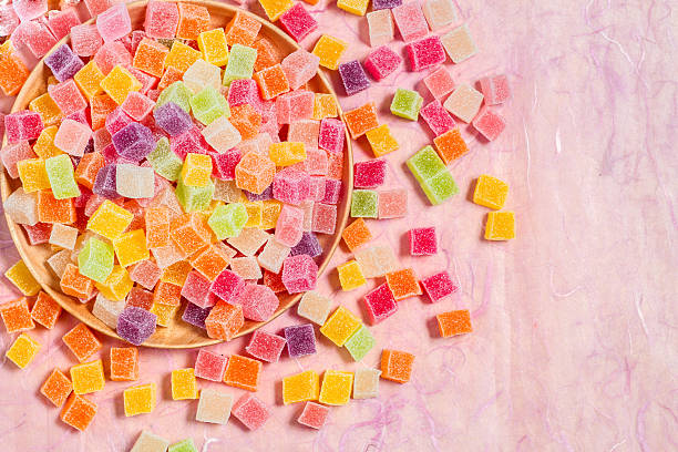 istock Colorful candy and jelly in dish on pink background 599996002